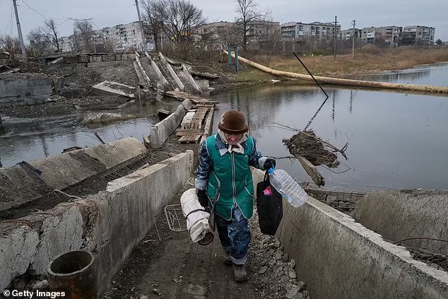 O femeie pe nume Lyudmila traversează un pod distrus pe fondul bombardamentelor de artilerie pe 24 decembrie în Bakhmut, Ucraina. Sursa foto: Daily Mail