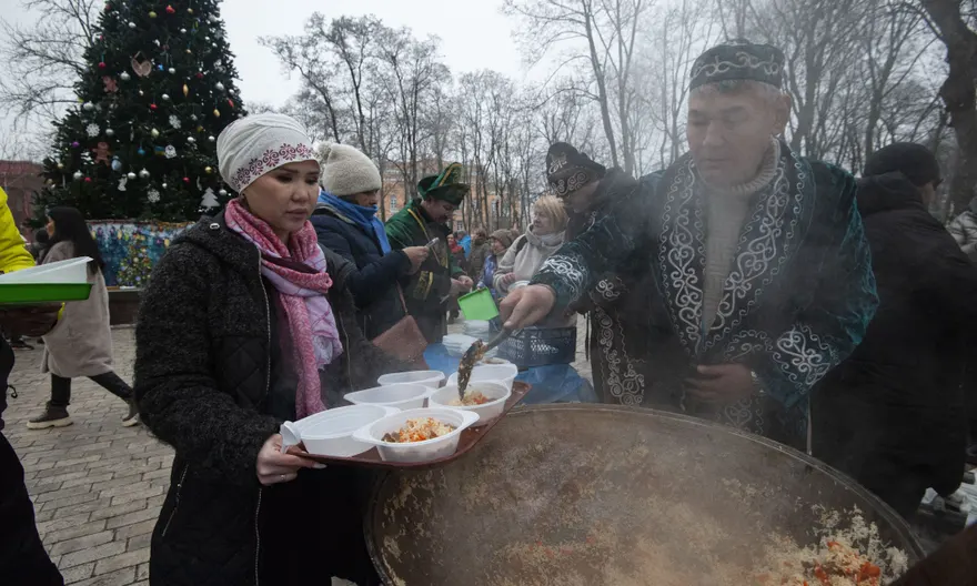 Membri ai diasporei kazahe pregătesc mâncare într-o "iurtă a invincibilității" din Kiev, unde oamenii își pot încărca telefoanele și se pot încălzi. Fotografie: Anadolu Agency/Getty Images