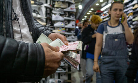 Bărbat numărând bani în piața de pantofi Kadikoy și clienți în fundal în faimosul cartier central al Istanbulului, Kadikoy Bazaar, pe 07 mai 2022, în Istanbul, Turcia. Inflația a urcat în aprilie în Turcia la aproape 70 69,97 pe un an, în aprilie, cel mai ridicat nivel din februarie 2002, potrivit cifrelor oficiale publicate pe 5 mai (dreamstime)
