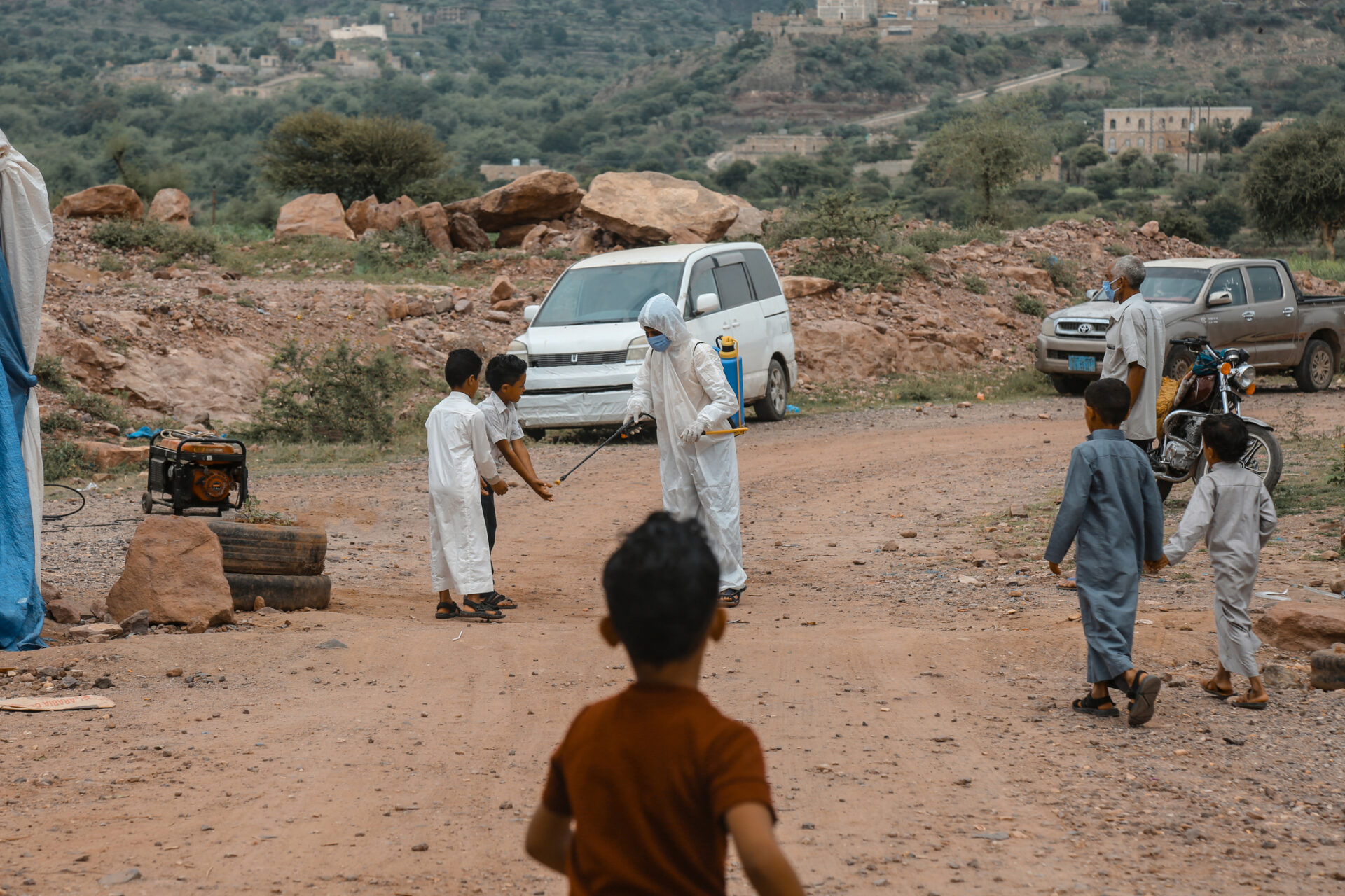 Un medic yemenit ce dezinfectează mâinile unor copii pentru a preveni infecția cu Covid 19 Corona în orașul Taiz, Yemen (sursă foto: dreamstime)