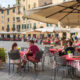 Persoane neidentificate care mănâncă preparate tradiționale italiene într-un restaurant în aer liber în centrul orașului Lucca, Italia. Sursă foto: Dreamstime