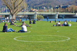 Cercuri albe pictate pe o pajiște de pe malul râului Neckar pentru a se asigura că oamenii păstrează distanța în timpul pandemiei, Heidelberg, Germania, Sursa foto: dreamstime.com