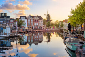 Orașul vechi Leiden, vedere a Beestenmarkt și a morii De Valk care se reflectă în râul Rin la răsăritul soarelui, Olanda de Sud, Țările de Jos
