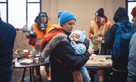 mama ucraineancă cu un copil in brate intr-un centru de ajutor