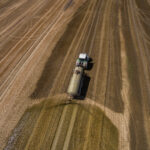 Vedere aeriană a unui tractor agricol cu o remorcă fertilizează un câmp agricol proaspăt arat cu gunoi de grajd, Sursa foto: dreamstime.com