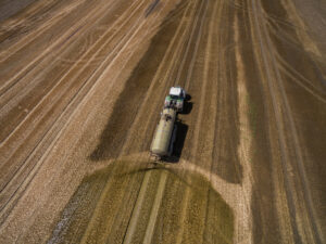 Vedere aeriană a unui tractor agricol cu o remorcă fertilizează un câmp agricol proaspăt arat cu gunoi de grajd, Sursa foto: dreamstime.com 