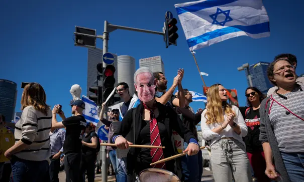 Un manifestant poartă o mască înfățișându-l pe Benjamin Netanyahu în timpul unui protest la Tel Aviv. Sursă foto: The Guardian