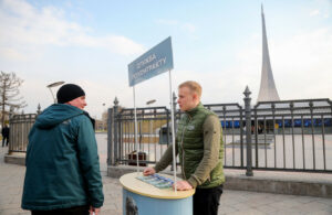 Un voluntar ține un stand de recrutare în fața centrului expozițional VDNKh din Moscova.