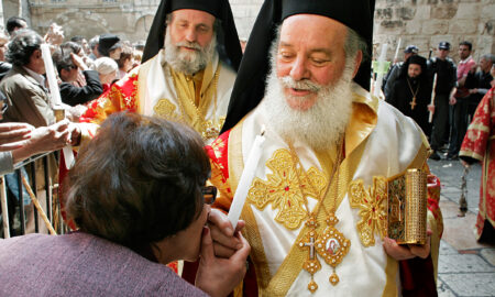 Preot ortodox oferind lumina unei femei la Ireusalim, Israel, De Paste